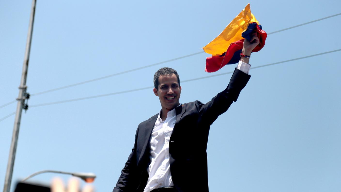 Juan Guaidó, di ritorno dal suo tour in cerca di sostegno, sventola la bandiera della sua nazione 