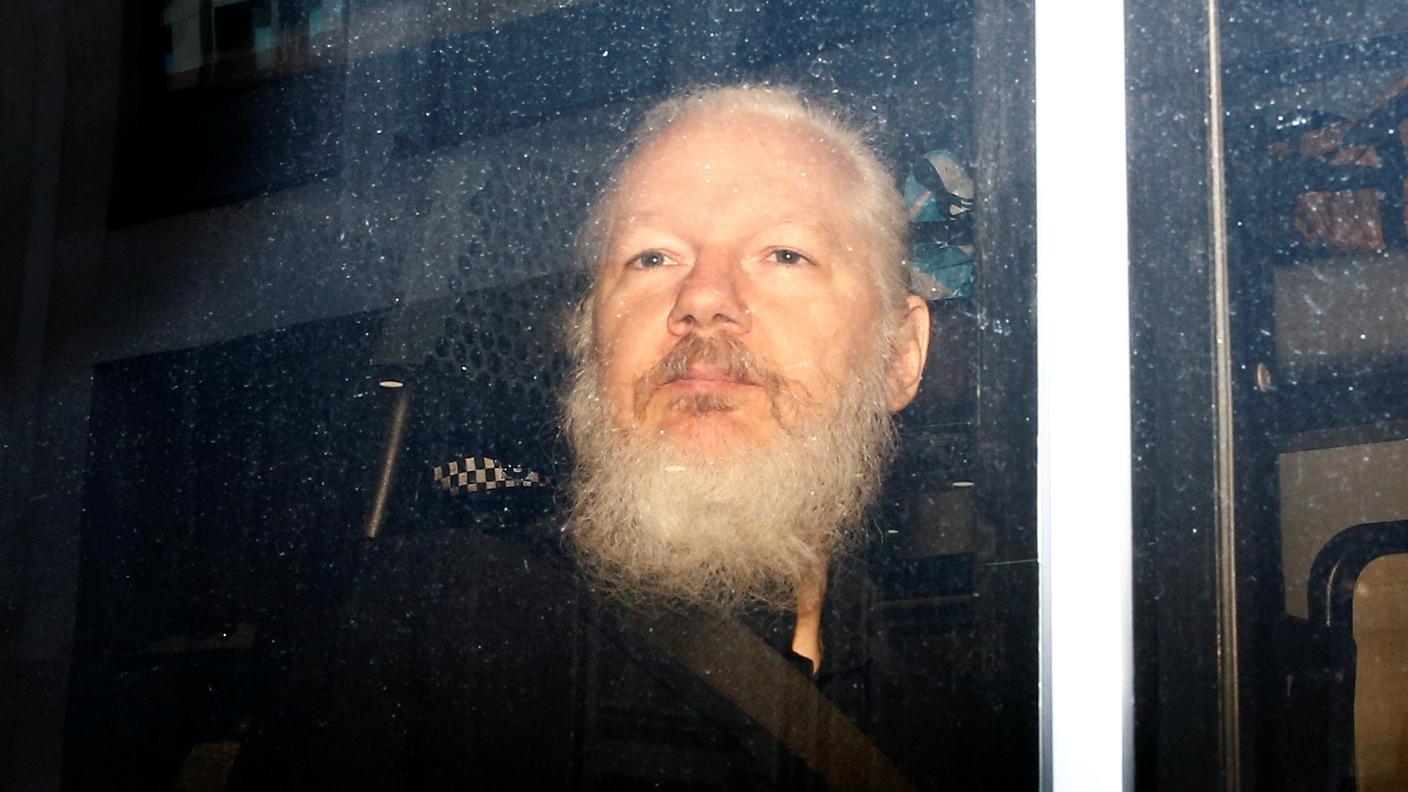 Assange a bordo del furgone della polizia dopo l'arresto