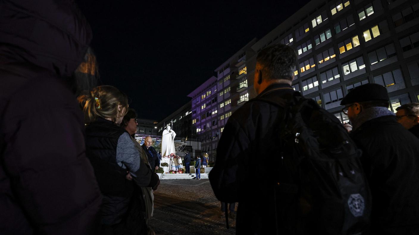 Fedeli in preghiera all'esterno del Policlinico Gemelli di Roma, dove Papa Francesco è ricoverato dallo scorso 14 febbraio
