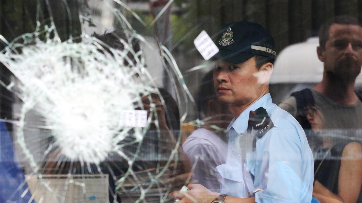 Un poliziotto dietro le vetrate infrante della sede del Parlamento