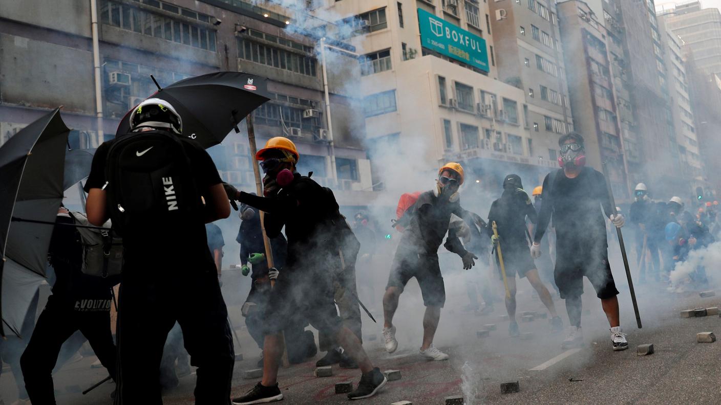 I manifestanti raggiunti dai gas lacrimogeni lanciati dai poliziotti a Hong Kong