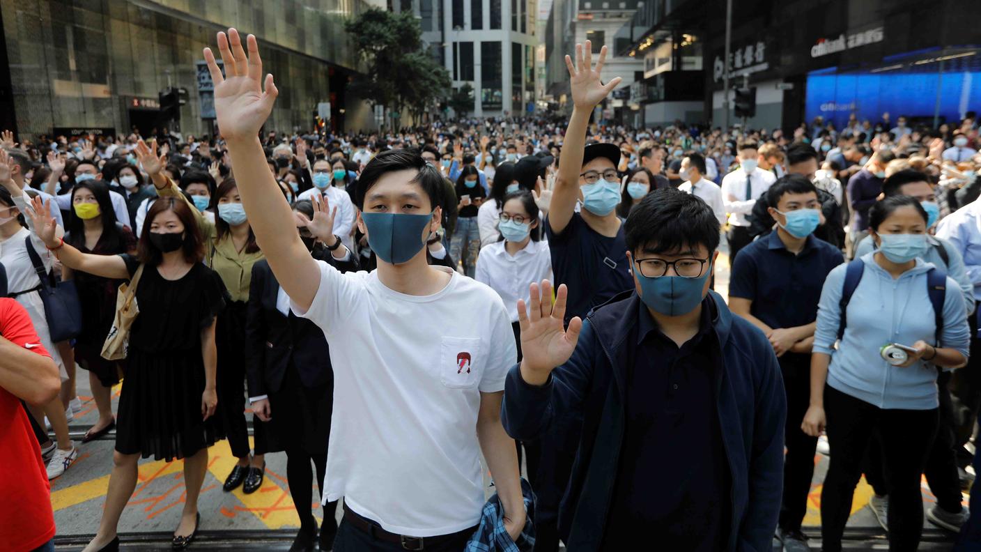Studenti e impiegati protestano mascherati venerdi nelle strade di Hong Kong