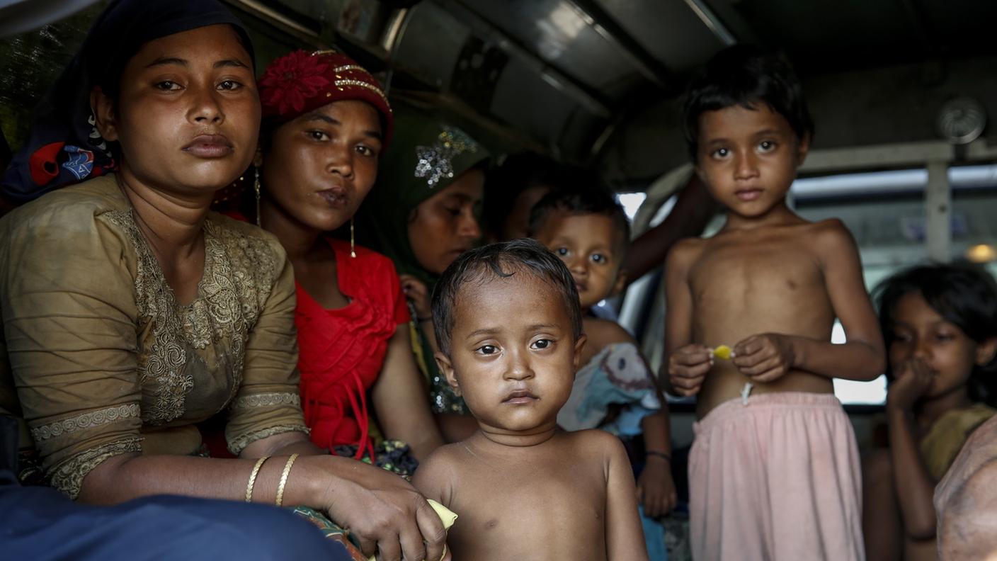 Donne e bambini rohingya a bordo di un camioncino mentre vengono trasferiti