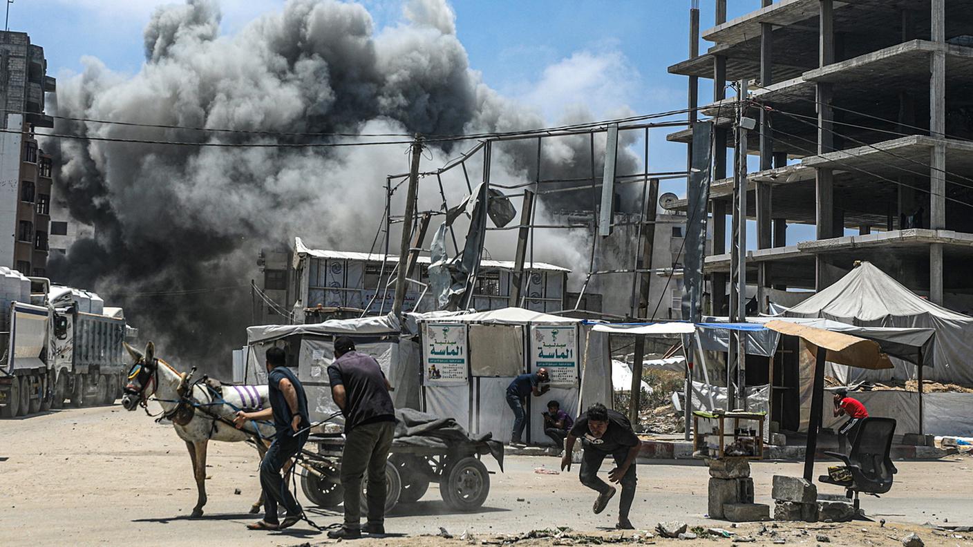 Palestinesi cercano riparo durante un bombardamento aereo israeliano a ovest di Gaza City, 23 maggio 2025