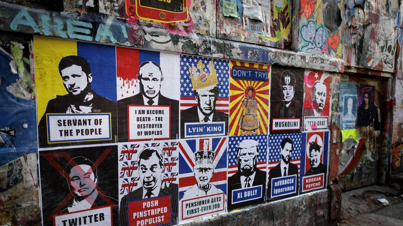 Poster di leader politici, tra cui Zelensky e Putin, sulle mura di Brick Lane a Londra