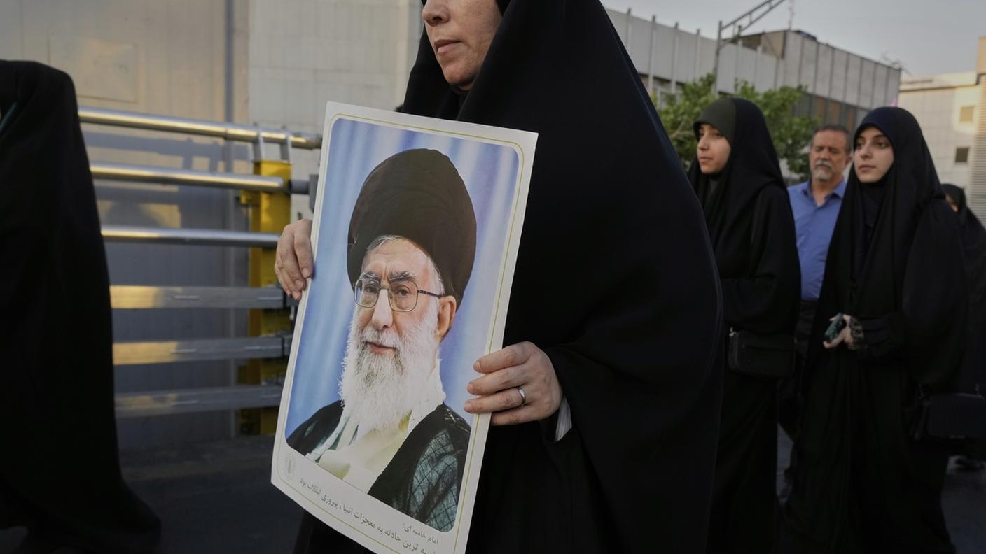 Una donna iraniana con l'immagine della Guida Suprema