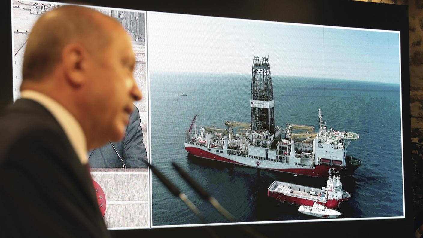 Il presidente turco Recep Tayyip Erdogan e una foto della nave da perforazione petrolifera Fatih