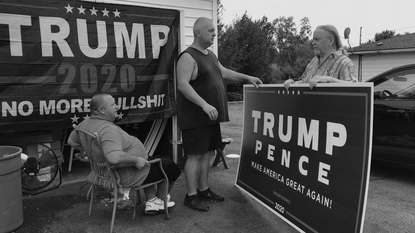 Dave Mitchko (seduto) distribuisce cartelli ai sostenitori del presidente. Era un democratico ma dopo aver perso il lavoro ha deciso di appoggiare Trump
