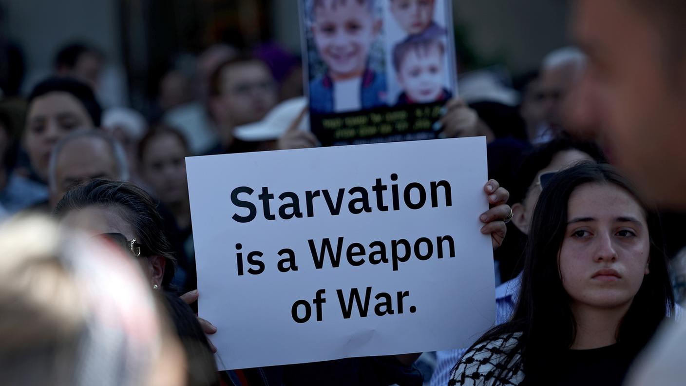 "La fame è un'arma di guerra", si legge su questo cartello esposto durante una protesta in Israele contro la politica del Governo Netanyahu