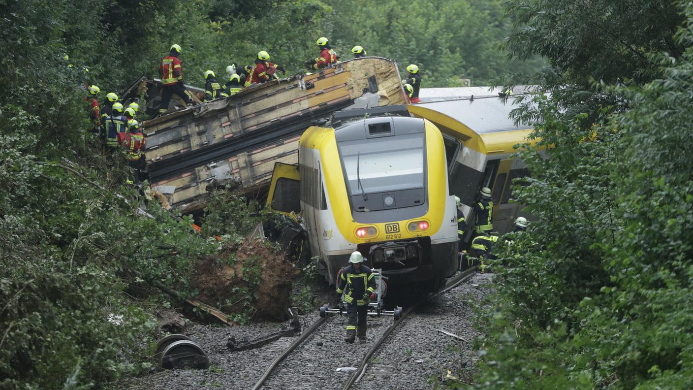 I soccoritori cercano passeggeri nel treno deragliato.