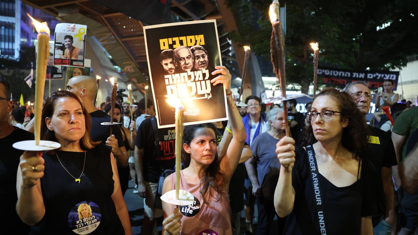 Manifestanti con cartelli di protesta a Tel Aviv (9 agosto 2025)