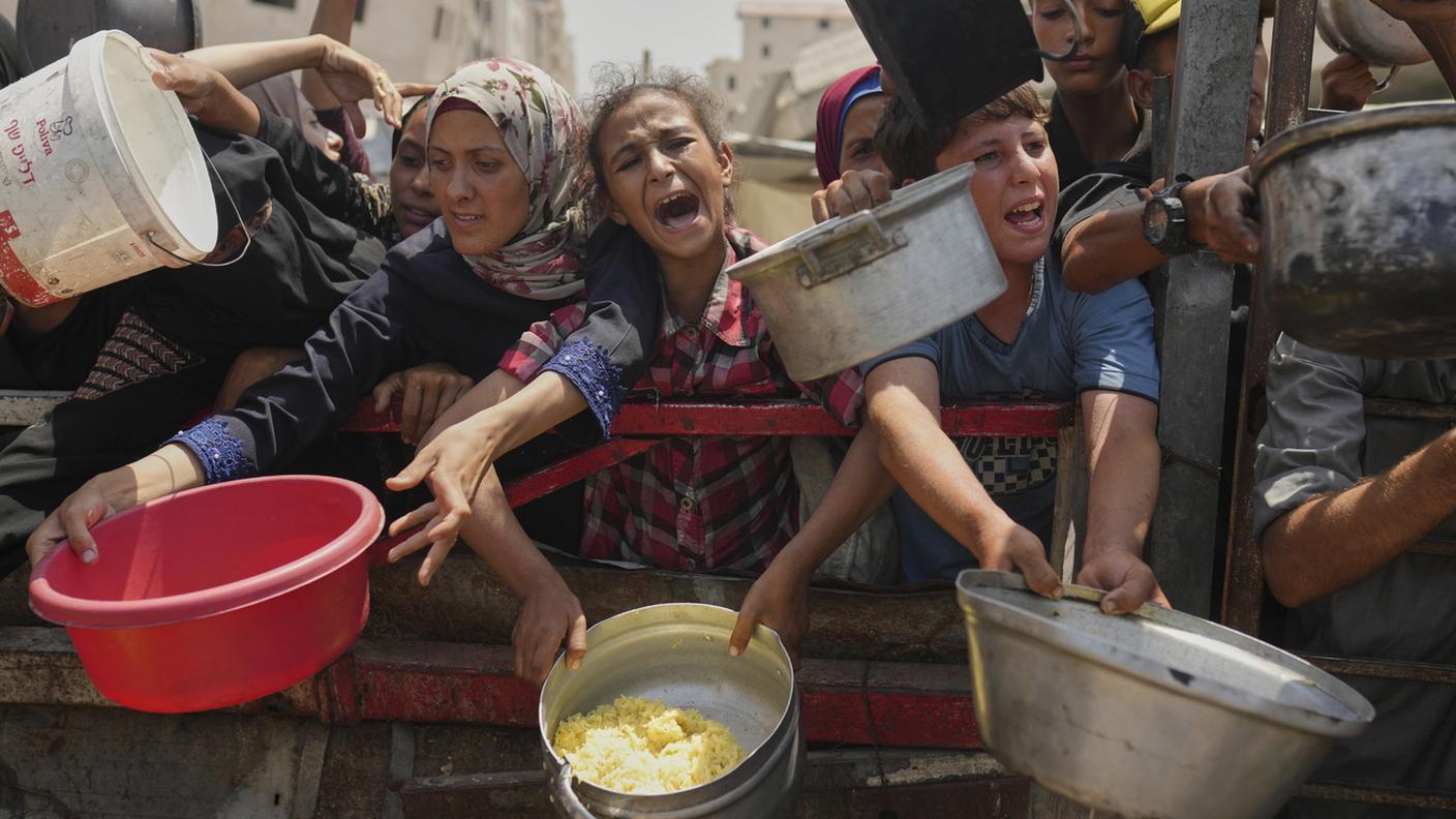Palestinesi disperati in cerca di cibo a Gaza City, nel nord della Striscia