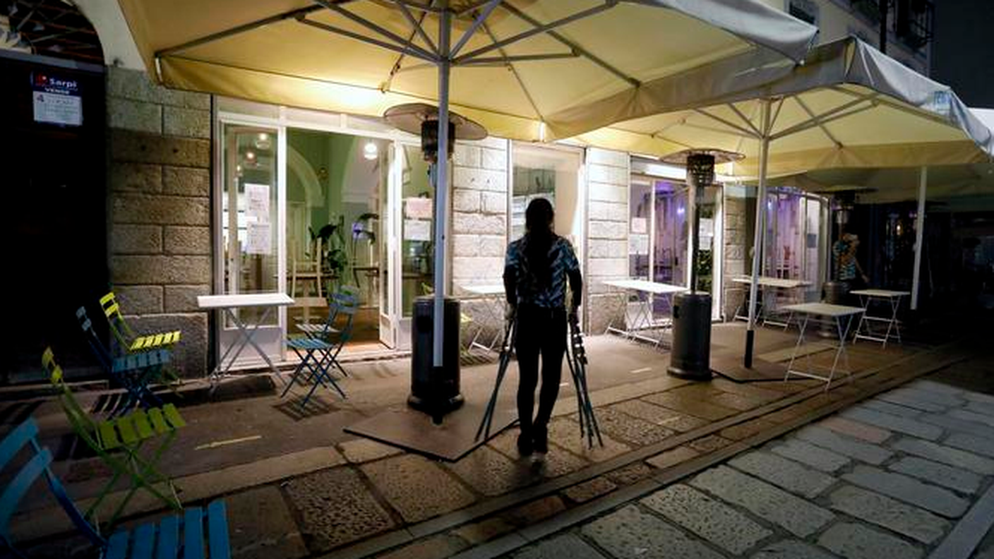 La chiusura di un locale prima del coprifuoco delle 23.00 sui navigli di Milano