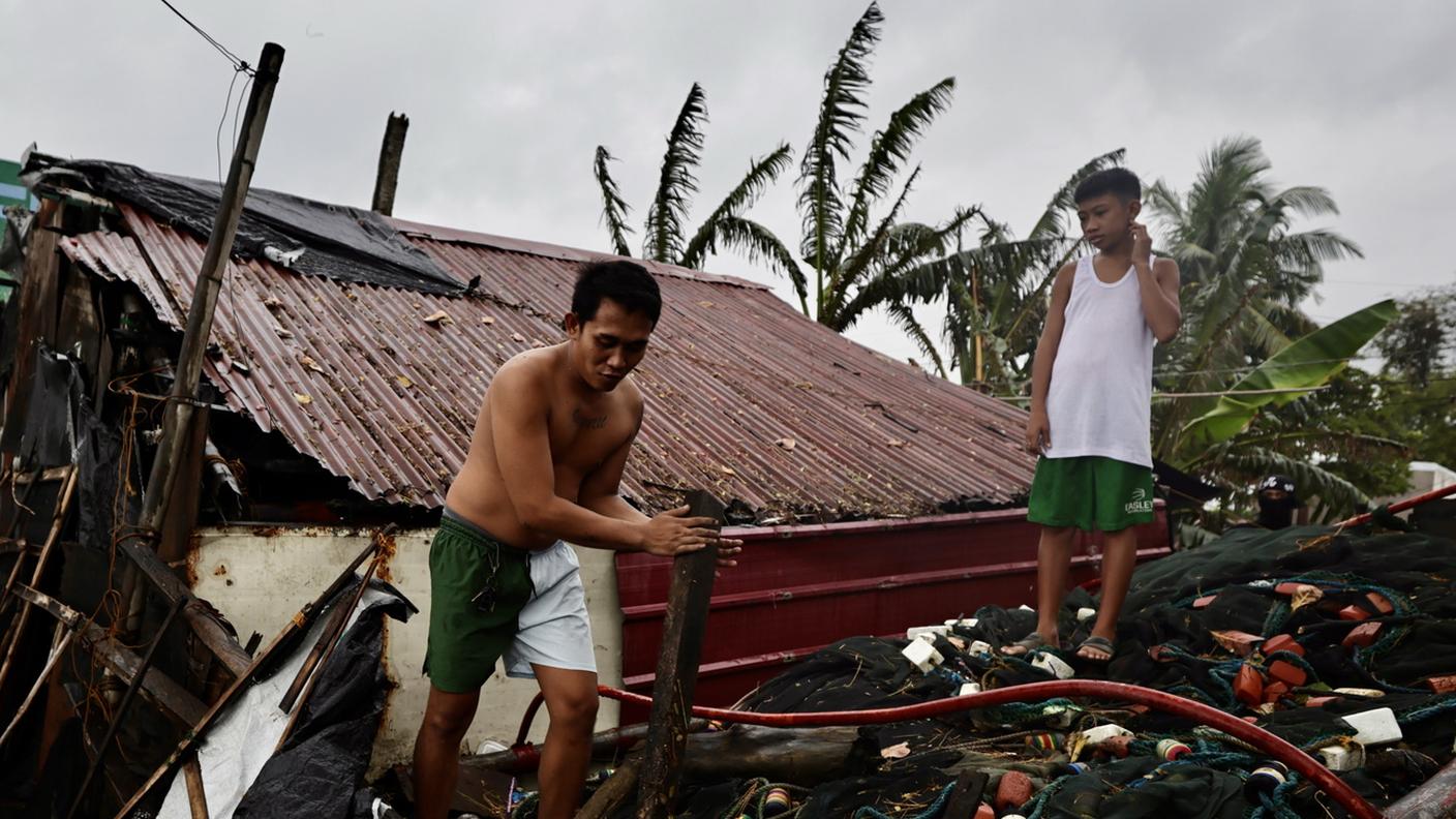 Abitanti della località di Cavite City controllano i danni dopo il passaggio del tifone nelle Filippine