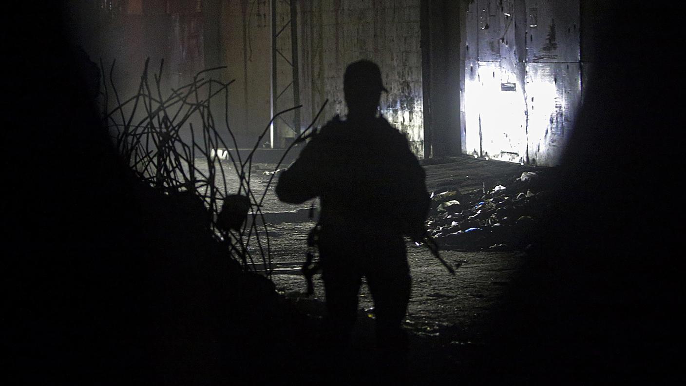 Combattenti palestinesi delle Brigate Izz ad-Din al-Qassam di Hamas sorvegliano l'arrivo dei veicoli per il trasporto dei resti degli ostaggi israeliani consegnati da Hamas a Gaza City, il 15 ottobre 2025