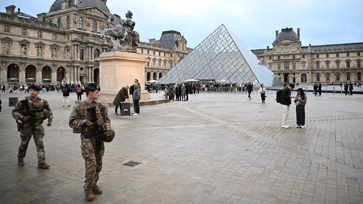 Soldati di pattuglia vicino all'ingresso del Louvre all'indomani del furto di gioielli compiuto domenica. (Foto del 20 ottobre 2025)