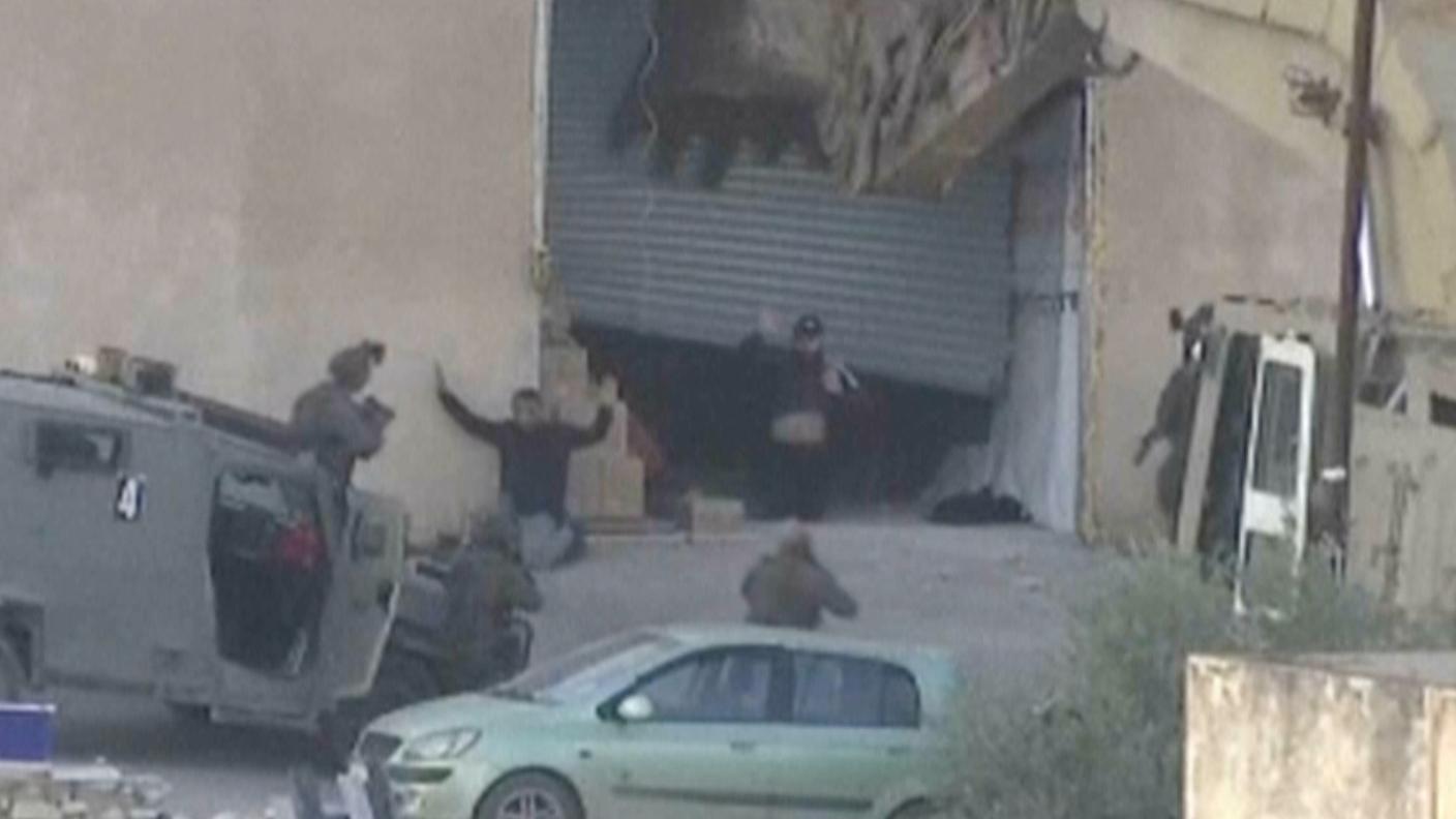 L'immagine tratta da uno dei video sull'accaduto: i due mentre escono con le mani in alto da un edificio circondato