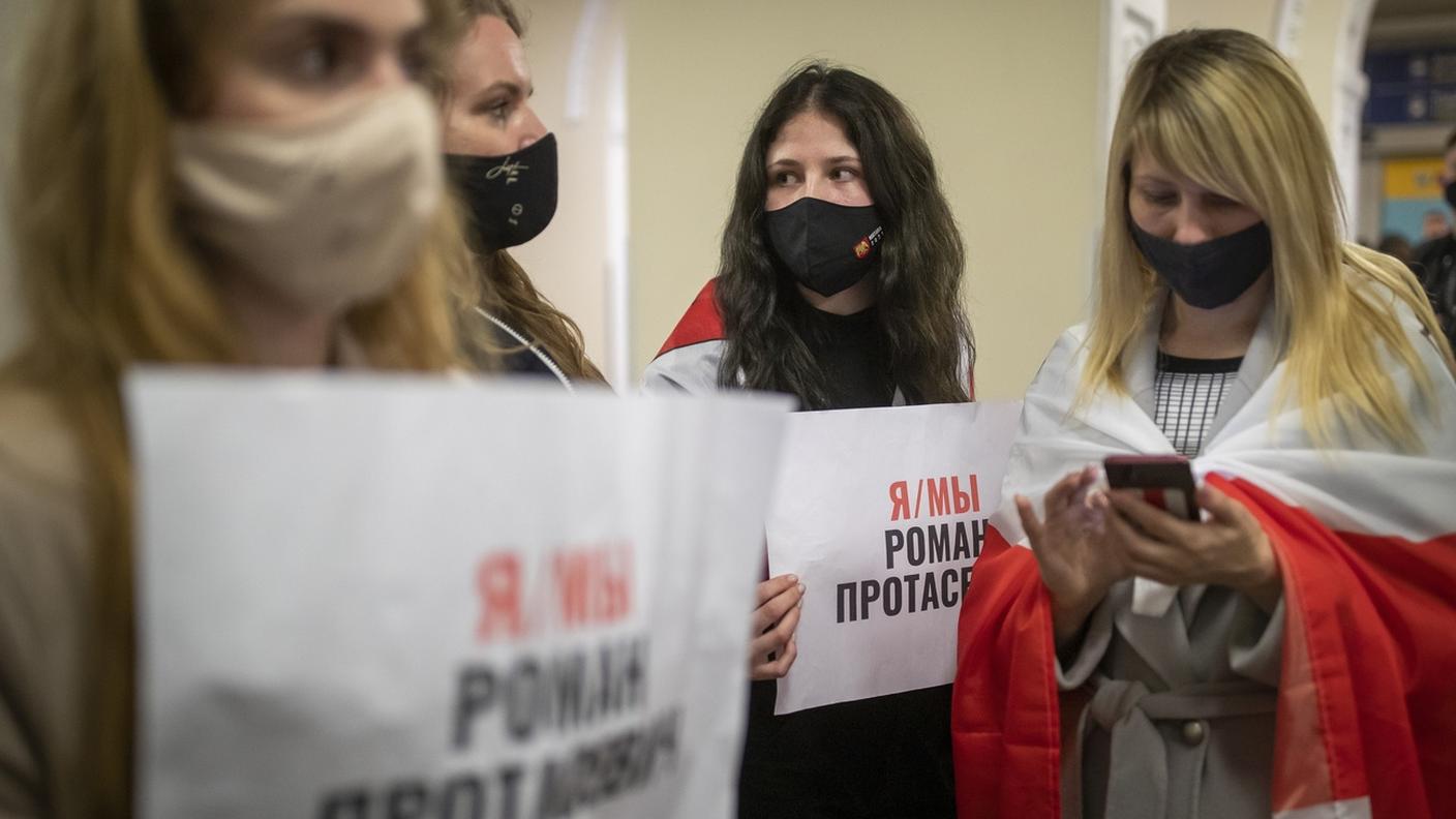 "Sono/Siamo Roman Protasevich", dicono i cartelli retti da queste donne all'aeroporto di Vilnius, dove l'apparecchio di Ryanair è giunto senza più a bordo l'oppositore di Lukashenko