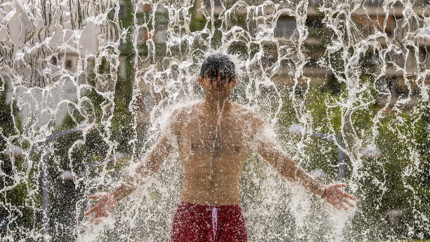 Un uomo cerca refrigerio in una fontana a Cordoba