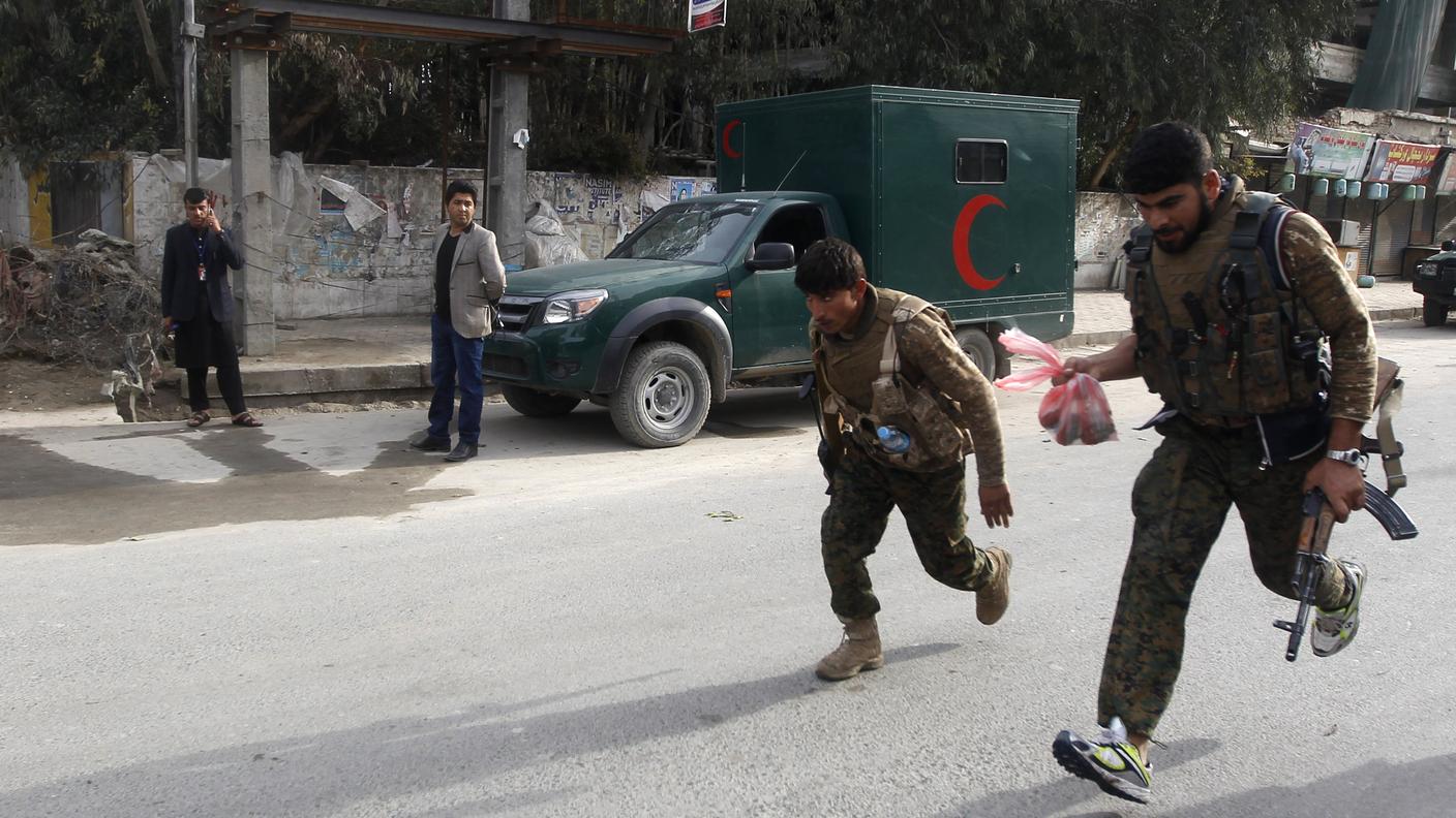 Agenti delle forze di sicurezza afghane fuggono dopo l'esplosione di un veicolo a Jalalabad