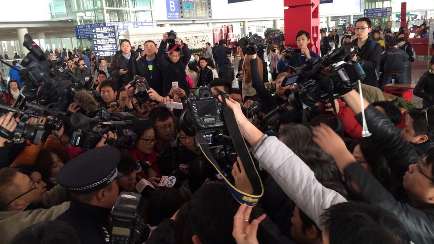 Reporter affollano la hall dell'aeroporto di Pechino, dove l'apparecchio era diretto