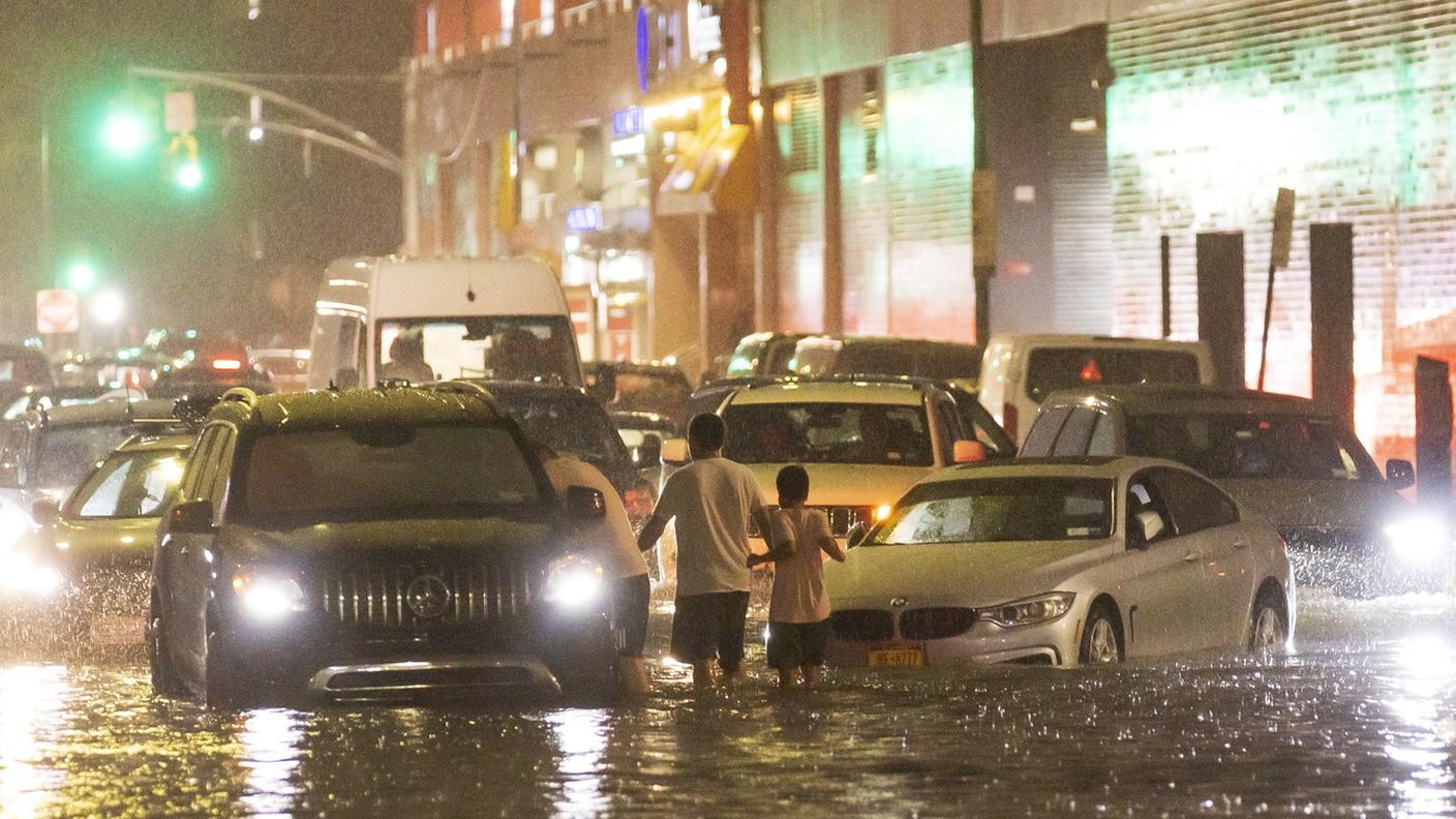 Strade inondate e auto in difficoltà nel quartiere Queens della metropoli