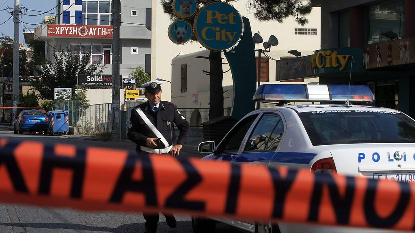Un agente della polizia greca presidia il punto dell'aggressione ad Atene