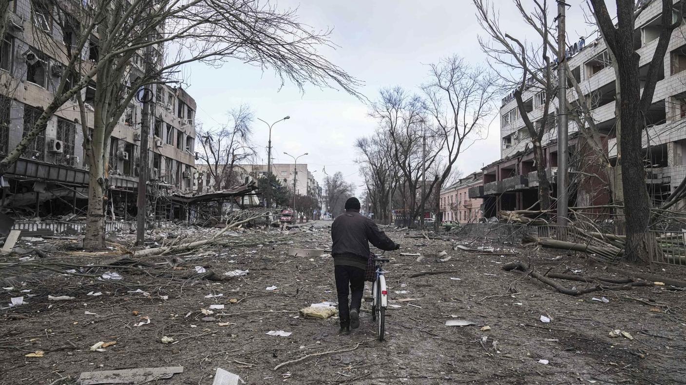 Un uomo cammina tra le macerie di Mariupol, in Ucraina