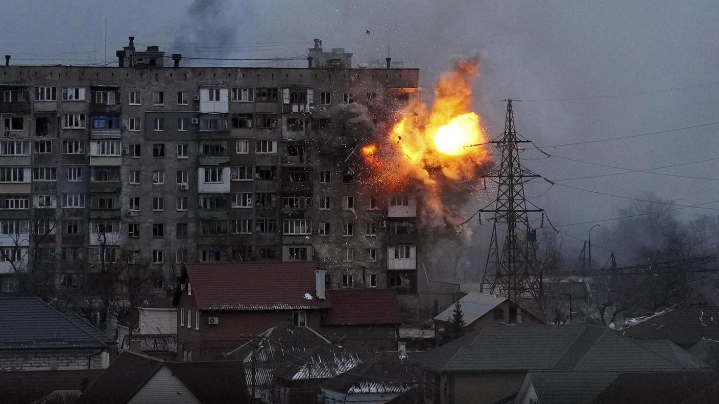Un'esplosione provocata dai bombardamenti russi in uno stabile di appartamenti a Mariupol