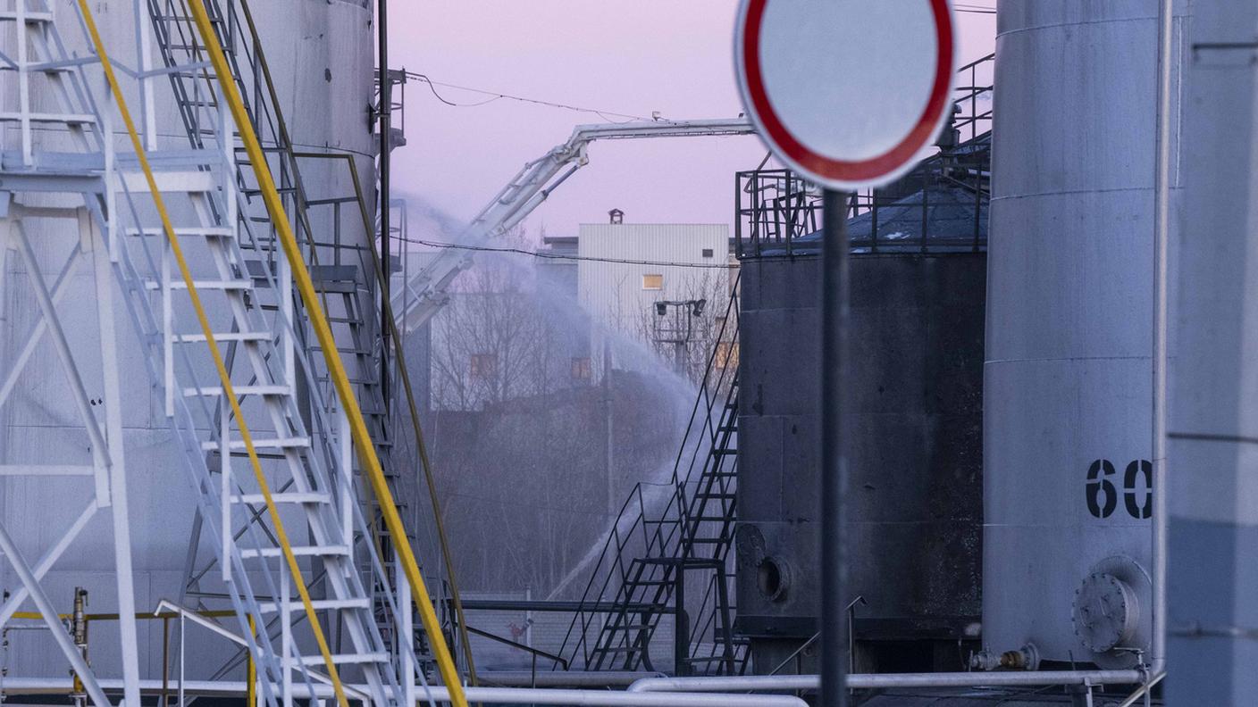 I pompieri al lavoro domenica mattina nel deposito di carburanti bombardato dai russi a Leopoli