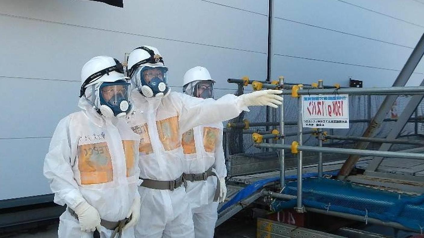 Tecnici della Tepco controllano il serbatoio danneggiato a Fukushima