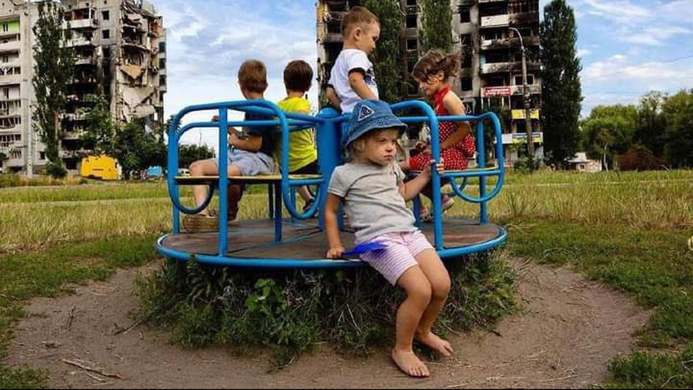 Bambini ucraini giocano vicino a ciò che resta di palazzi residenziali a Kharkiv