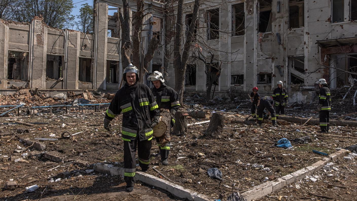 Pompieri ucraini impegnati nello sgombero di macerie dopo un bombardamento russo