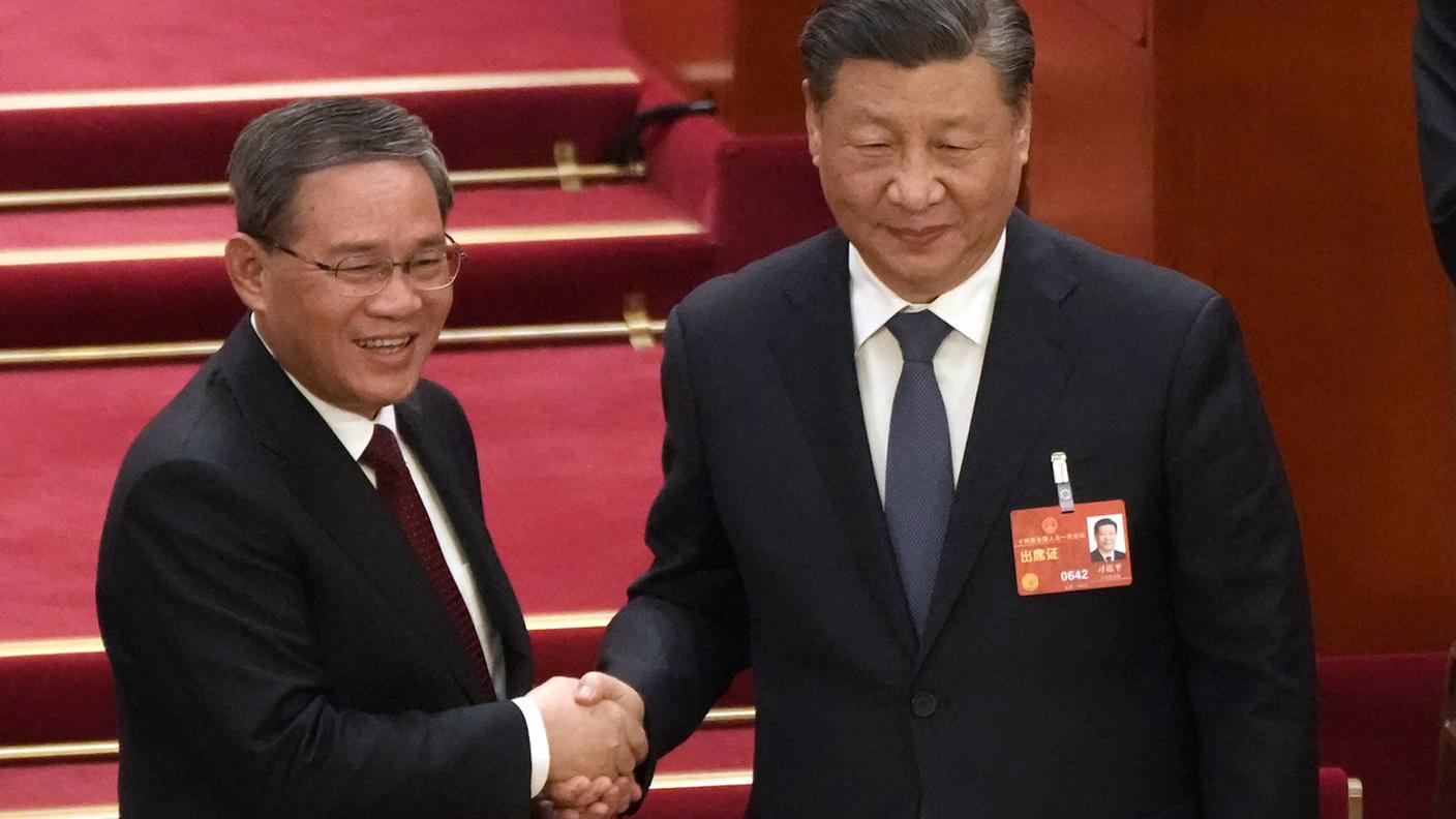 La stretta di mano tra il nuovo premier e il riconfermatissimo presidente Xi Jinping