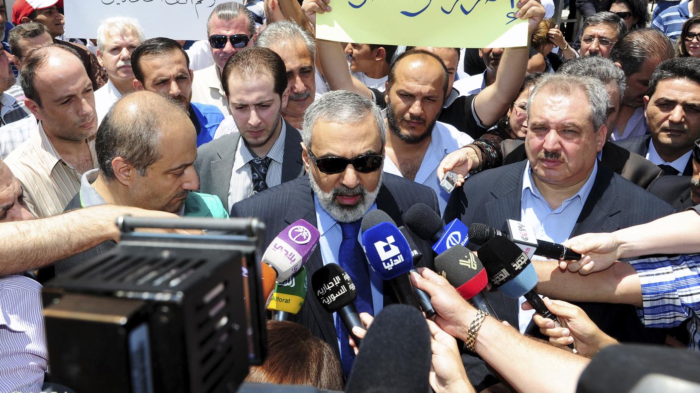 Il ministro Omran al-Zoubi accerchiato dalle telecamere