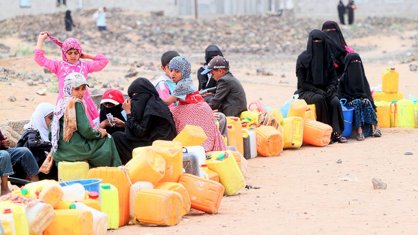 Un gruppo di persone in fila per ottenere dell'acqua in Yemen