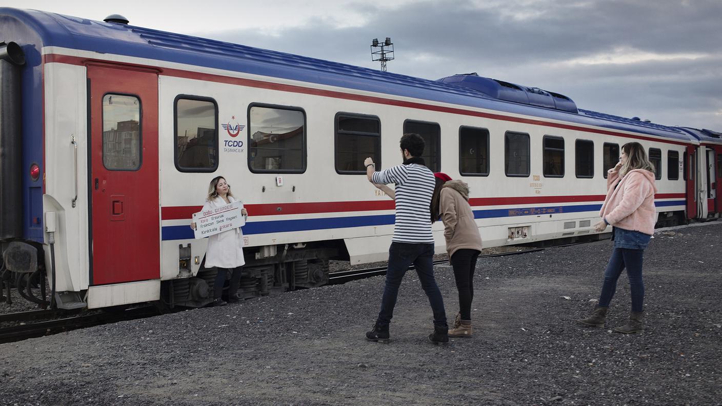 Giovani viaggiatori, utenti di Instagram, si fotografano tenendo in mano il cartello del  famoso Espresso dell’Est