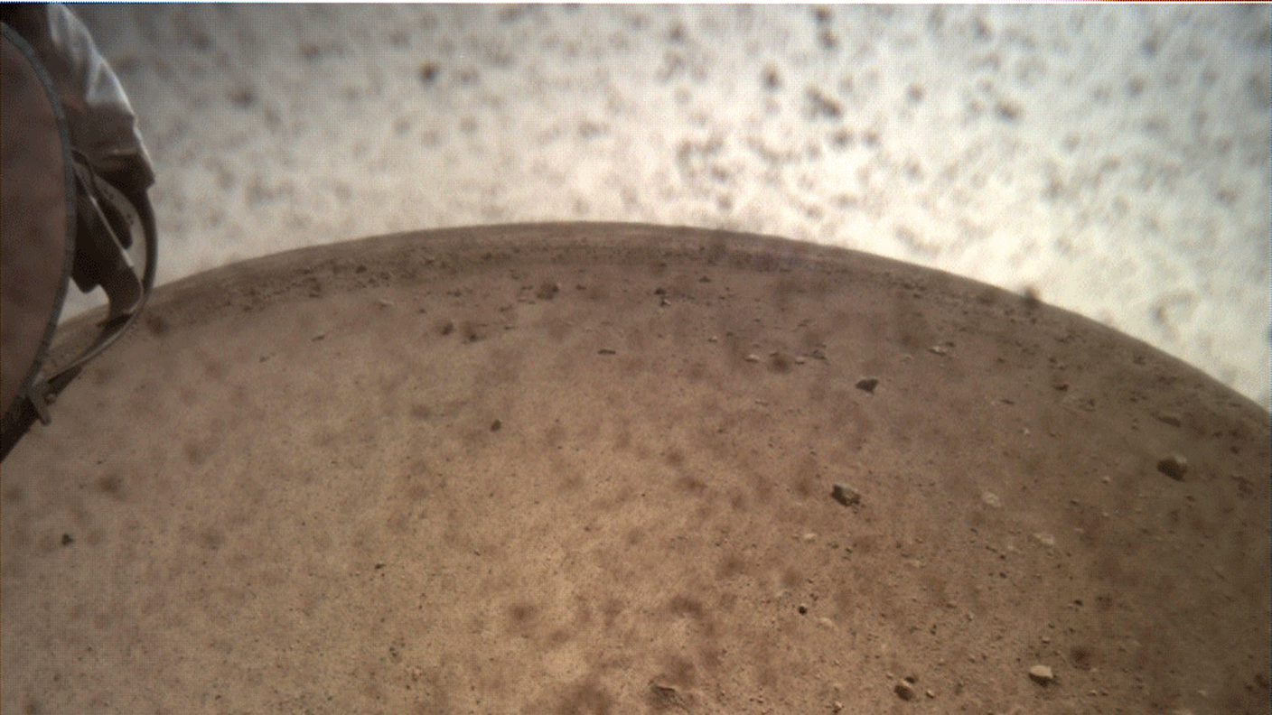 La rima immagine invita da InSight dalla superficie di Marte dopo aver rimosso la copertura della camera