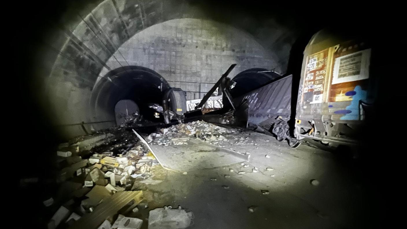 Una foto scattata dentro il tunnel dopo l'incidente; sulla destra il treno merci deragliato