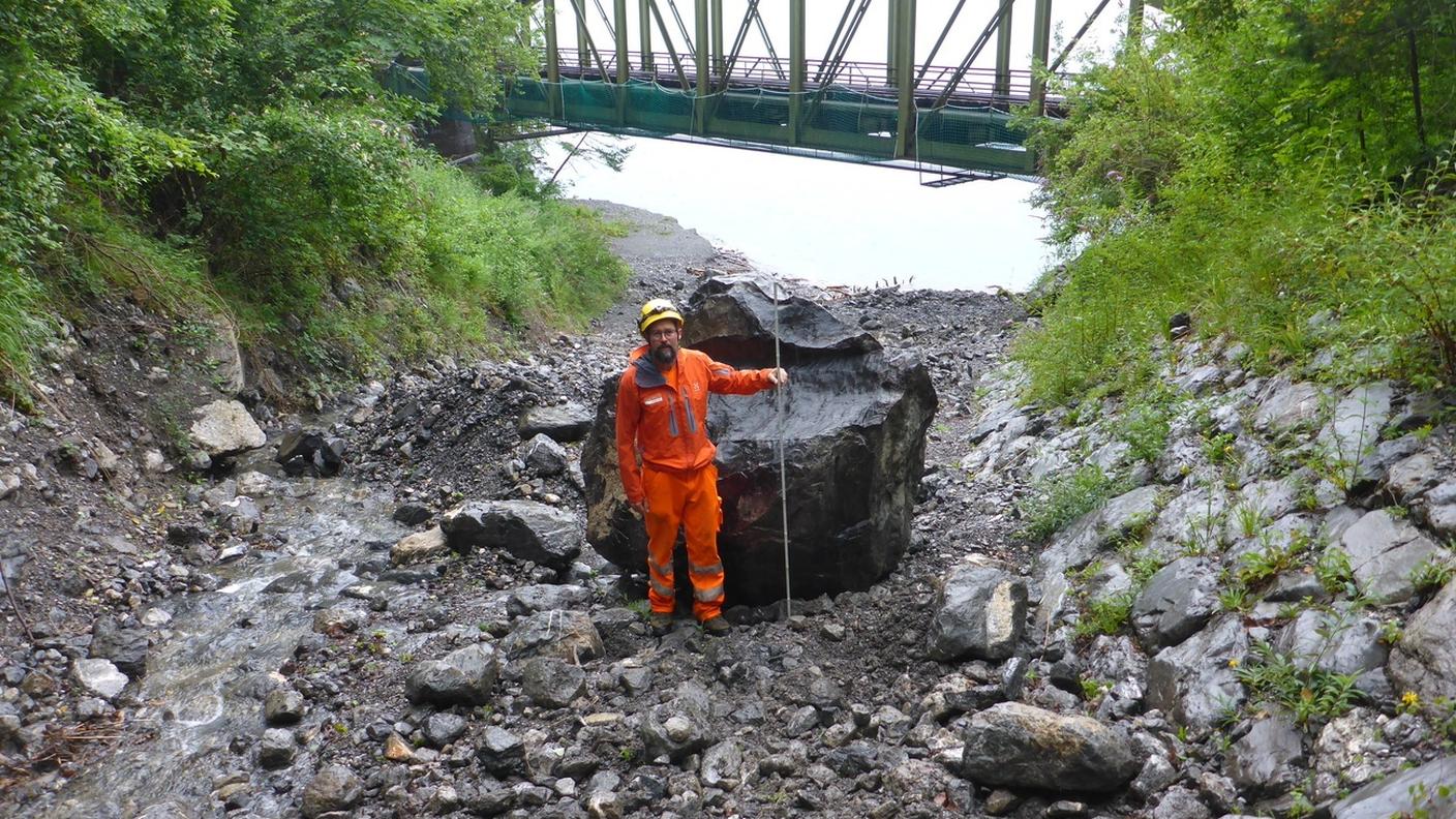 Un operaio vicino a uno dei massi precipitati sull'Axenstrasse a fine luglio
