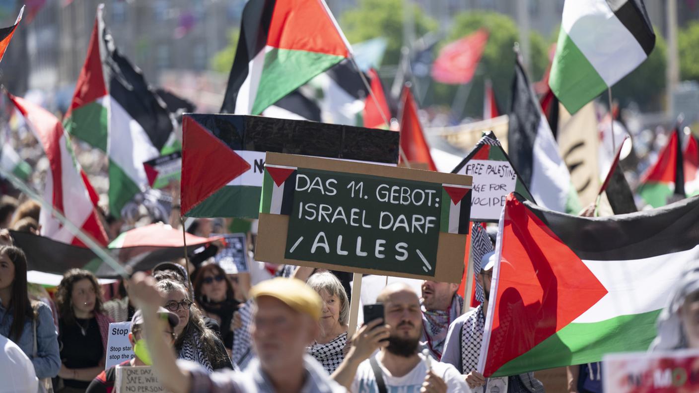 Manifestanti con bandiere palestinesi contestano la partecipazione di Israele