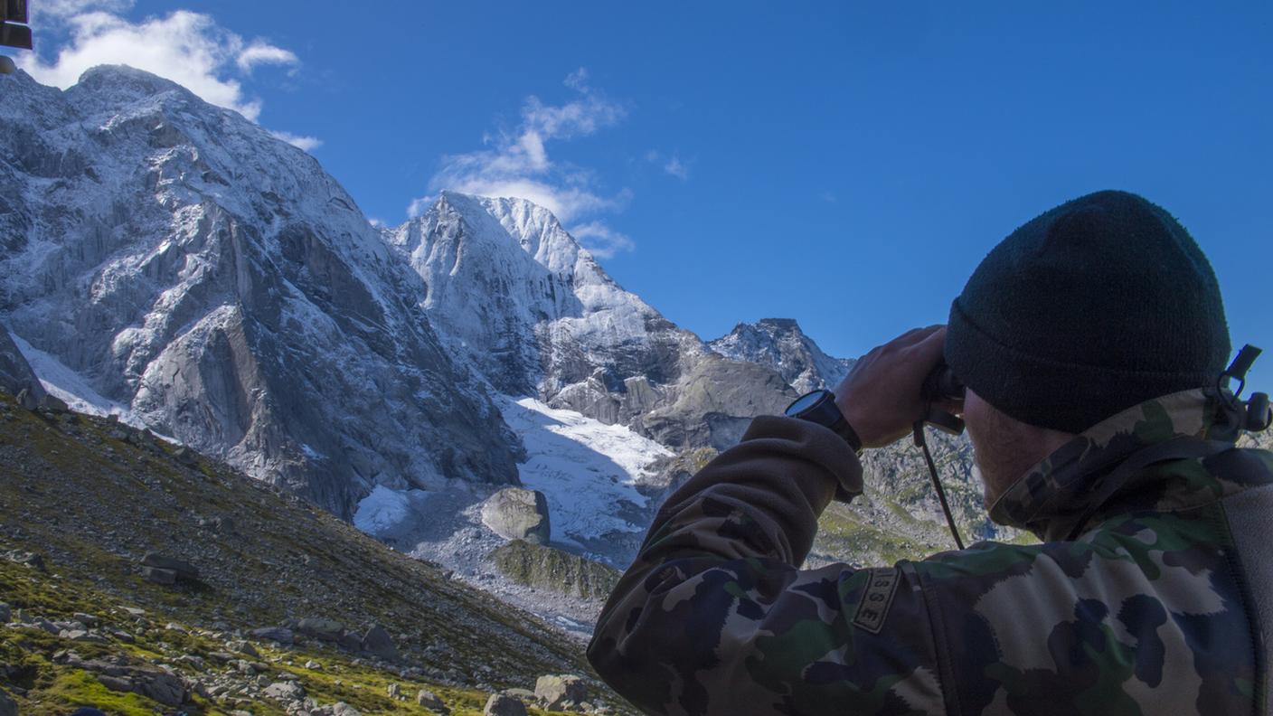 Un militare osserva il Pizzo Cengalo da cui nel 2017 si staccò la frana su Bondo