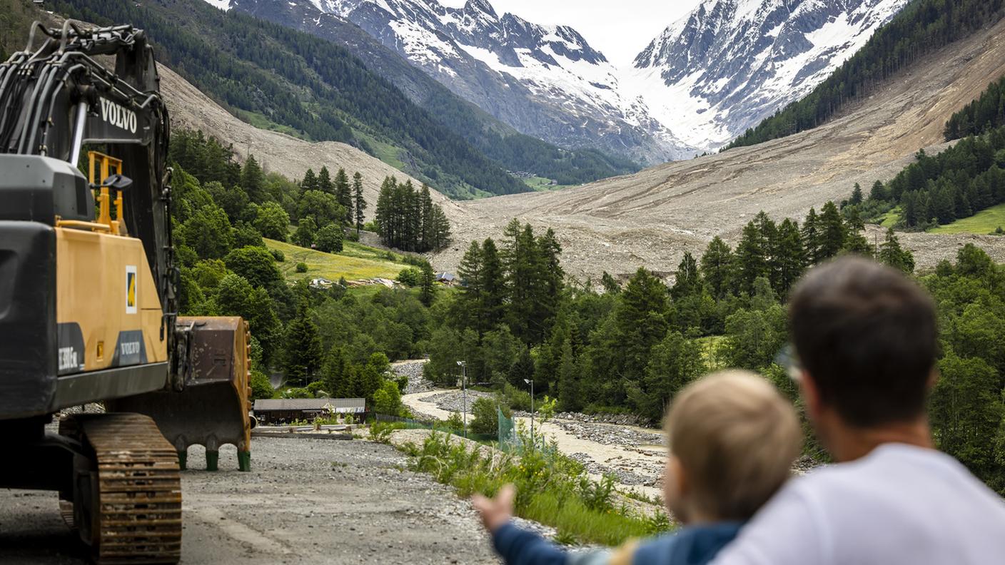 Un uomo e un bambino osservano la frana di Blatten