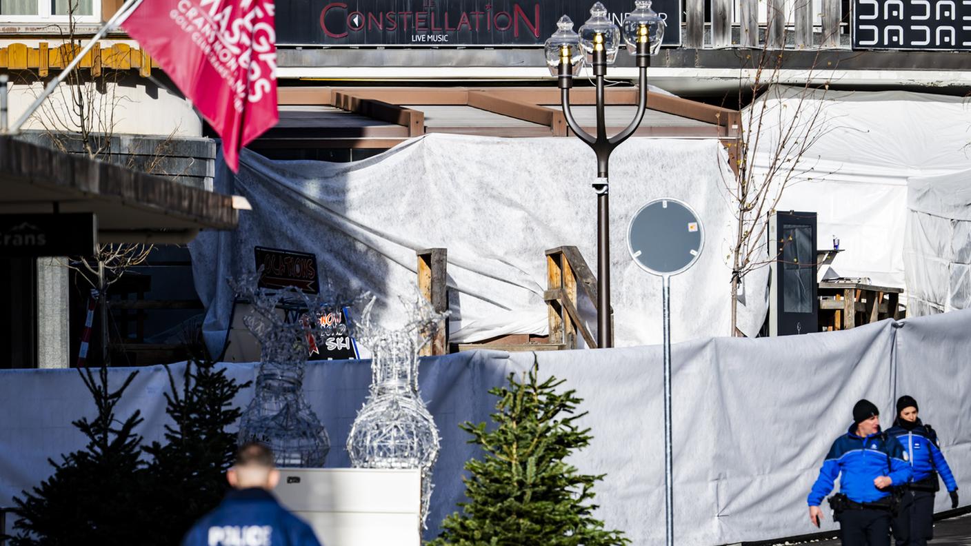 Agenti di polizia all'esterno del bar "Le Constellation", dove è scoppiato l'incendio: l'area è stata coperta da teli