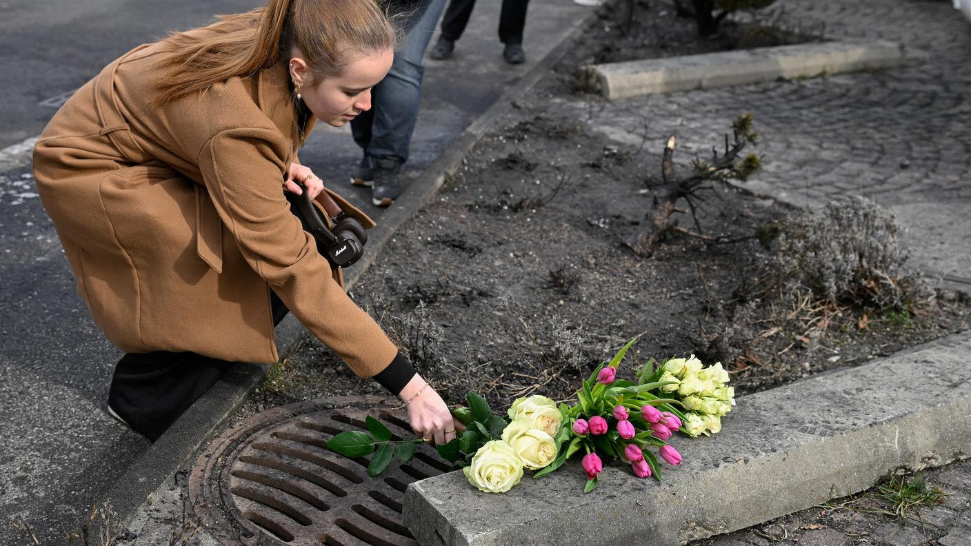Una donna posa un fiore sul luogo della tragedia