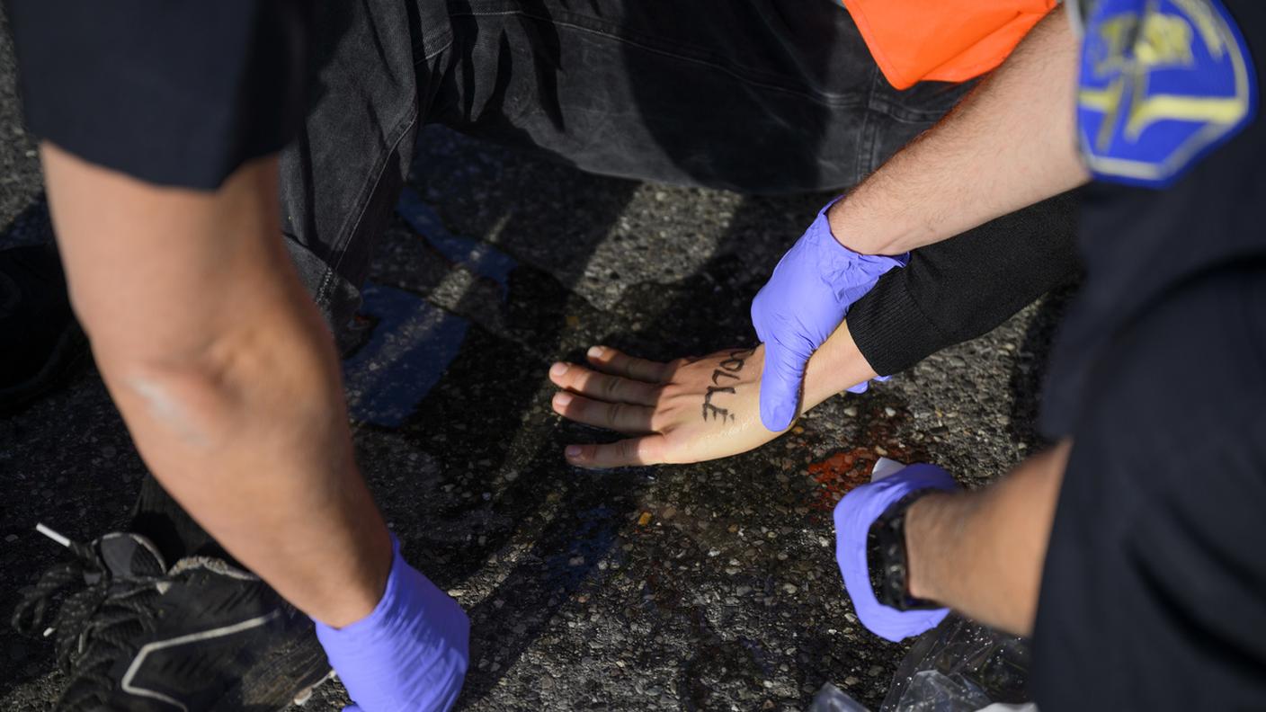 Operatori sanitari sono intervenuti per liberare dall'asfalto le mani di due dimostranti