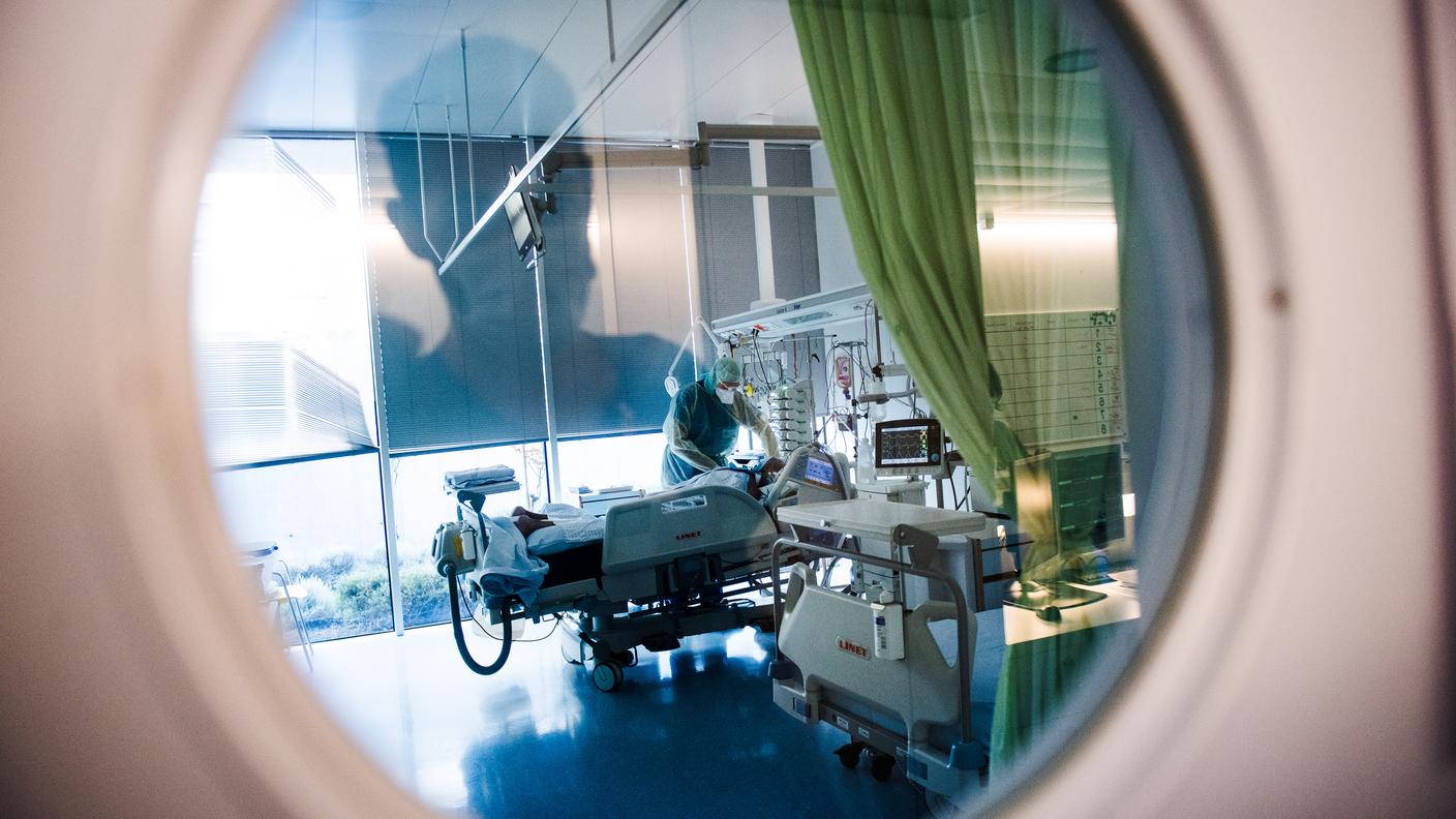 Un operatore sanitario al capezzale di un malato di Covid-19 ricoverato all'ospedale La Carità di Locarno