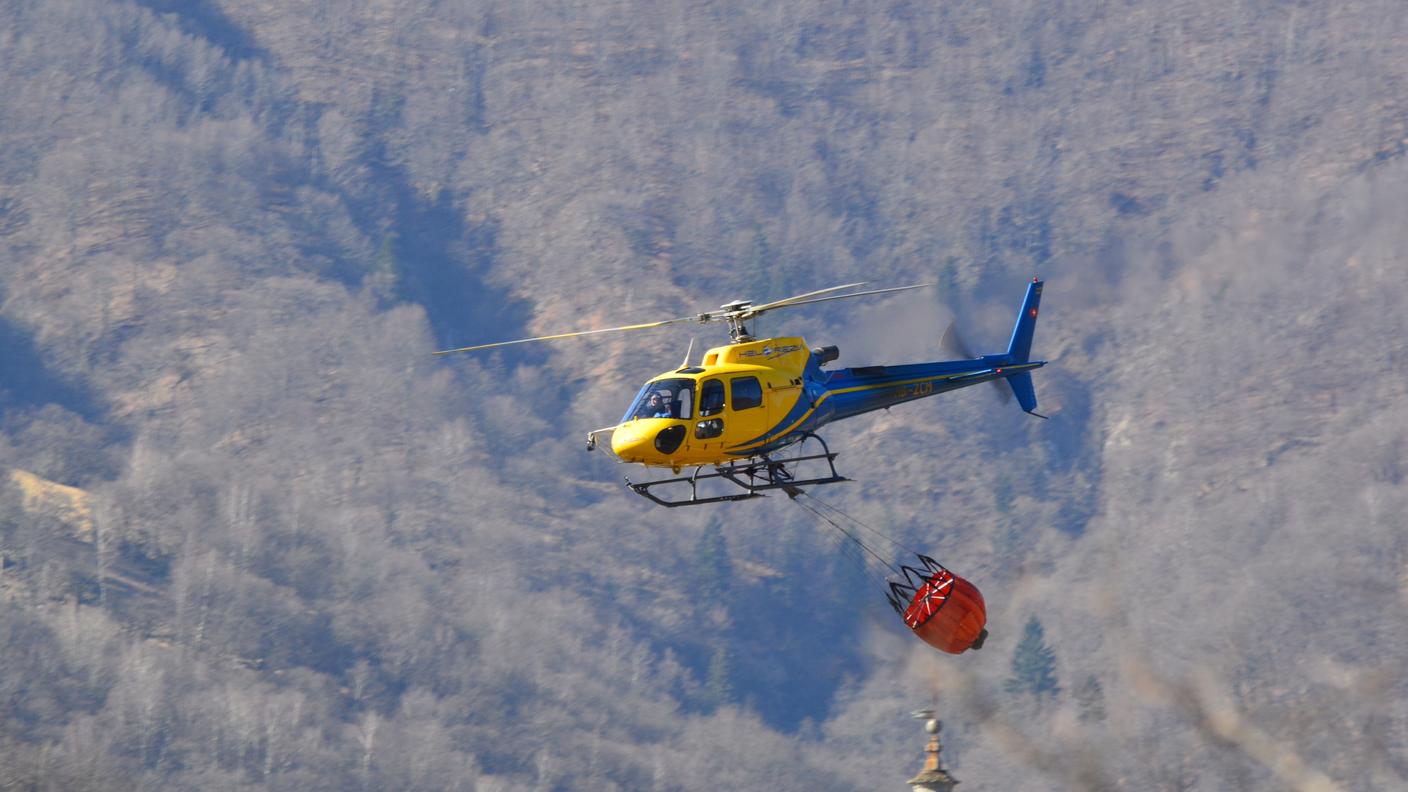 Pompieri in azione con l'appoggio di elicotteri