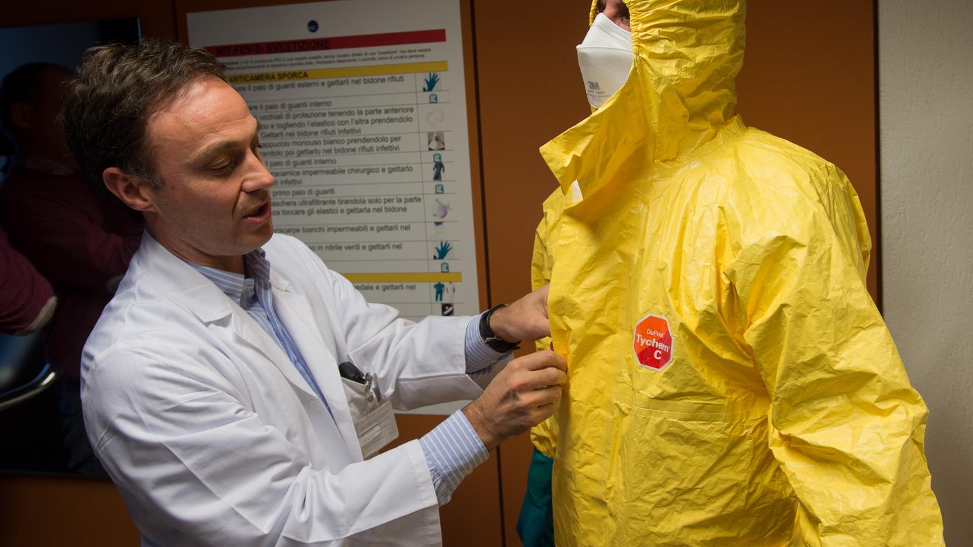 Il primario di medicina intensiva Paolo Merlani aiuta un infermiere nella vestizione