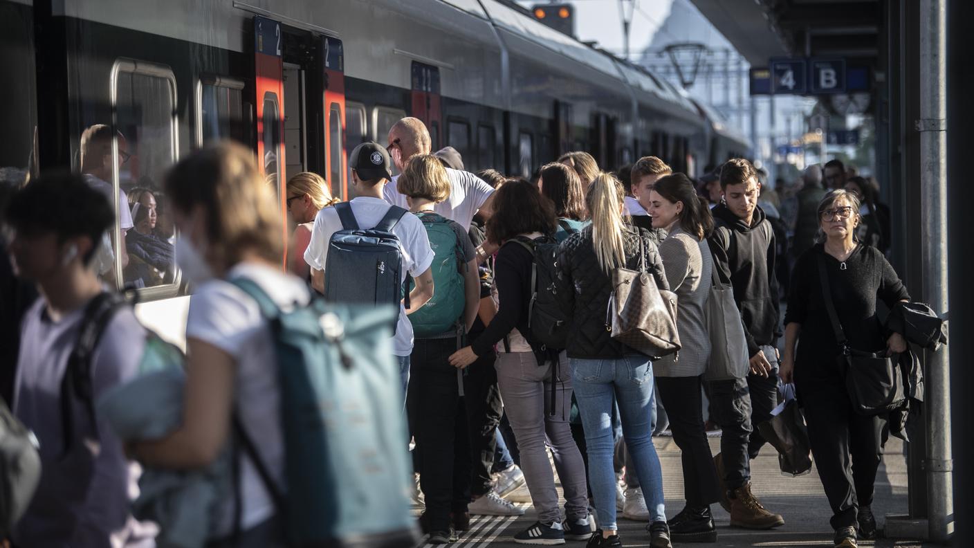 Nella foto, viaggiatori in movimento presso la Stazione FFS di Lugano